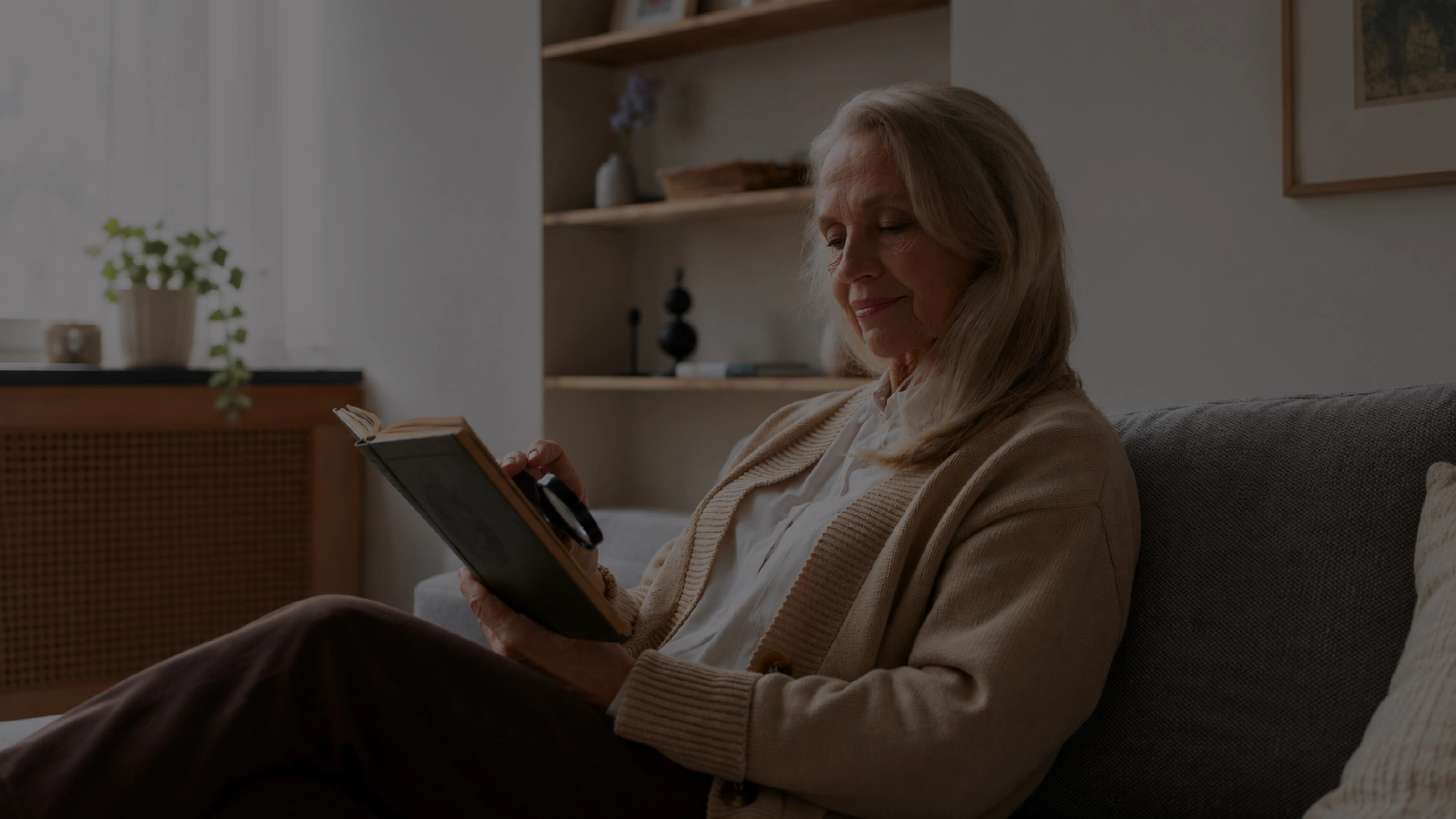 Mujer mayor leyendo un libro en su living